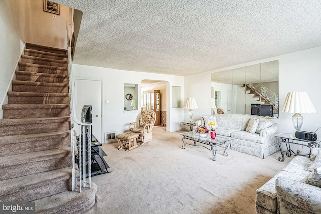 carpeted living room featuring a textured ceiling