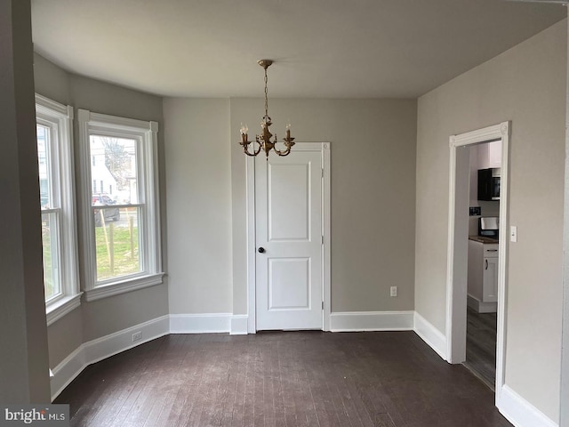 unfurnished dining area with a notable chandelier and dark hardwood / wood-style floors