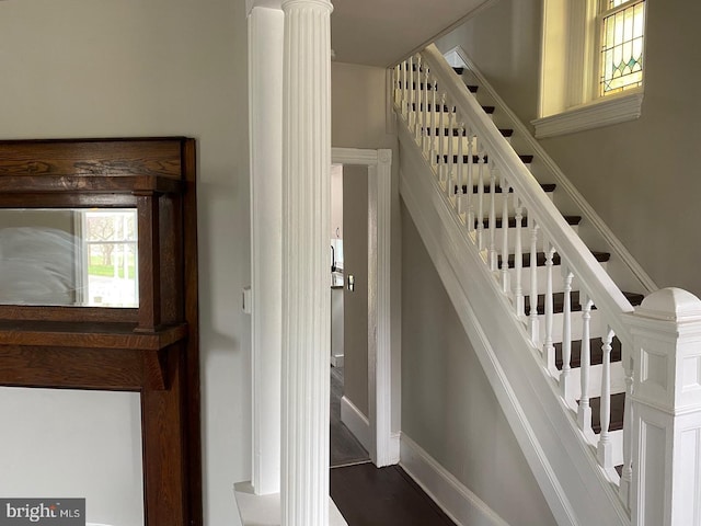 stairs featuring decorative columns and hardwood / wood-style floors