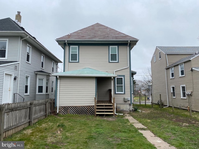 rear view of property featuring a yard