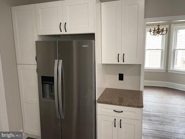 kitchen with wood-type flooring, a chandelier, stainless steel fridge with ice dispenser, dark stone counters, and white cabinets