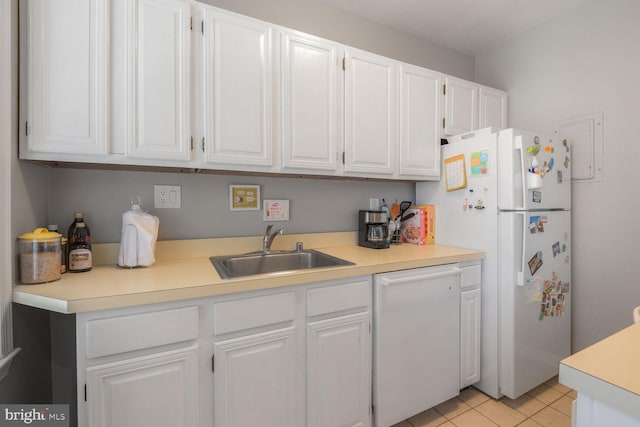 kitchen with white appliances, white cabinets, light tile patterned floors, and a sink