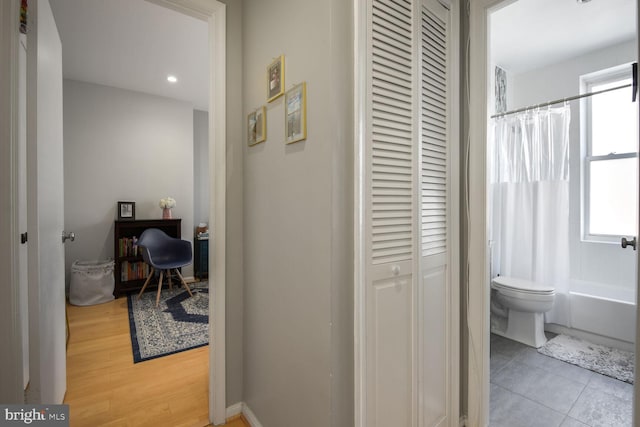 corridor featuring light tile patterned flooring and a healthy amount of sunlight