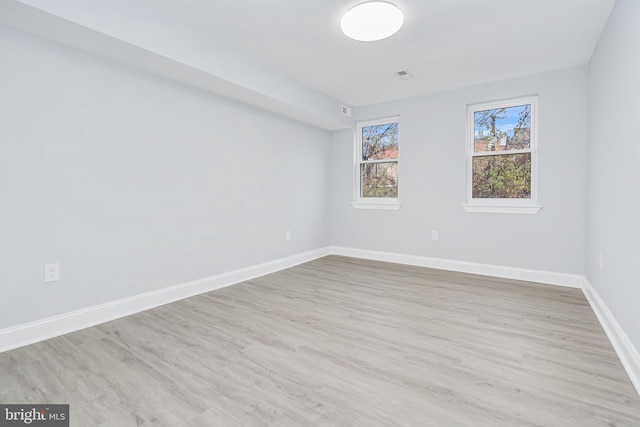 spare room featuring baseboards and wood finished floors
