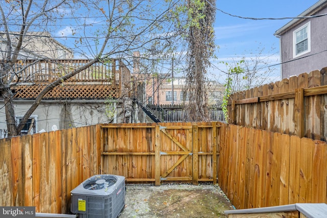 view of yard with fence, a gate, and central AC unit