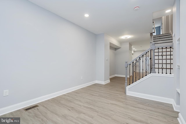 interior space featuring baseboards, stairs, wood finished floors, and visible vents
