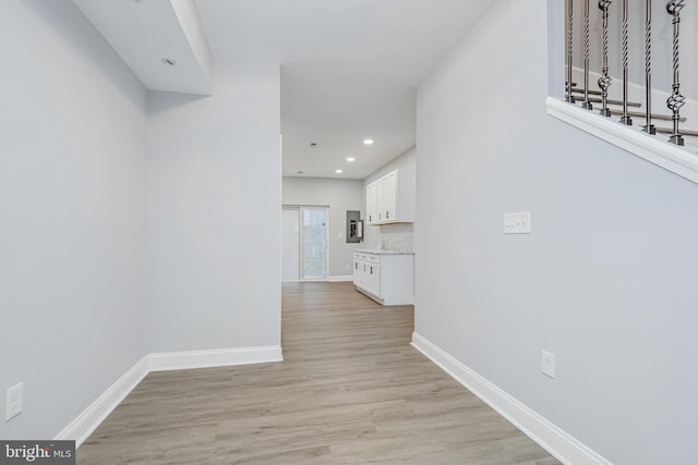 hallway with light wood-style floors, recessed lighting, and baseboards