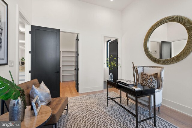 office space featuring light hardwood / wood-style flooring and a high ceiling