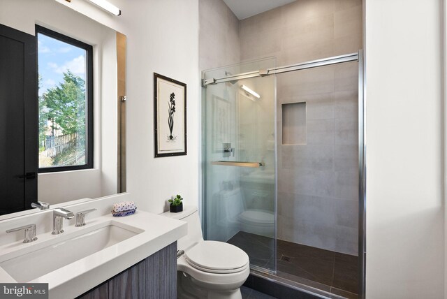 bathroom featuring walk in shower, vanity, and toilet