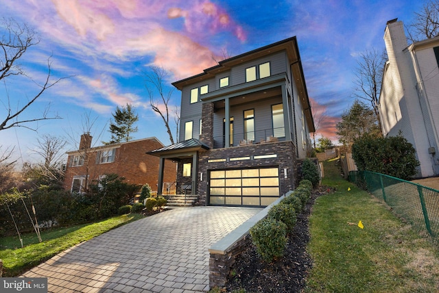 contemporary home featuring a garage and a yard