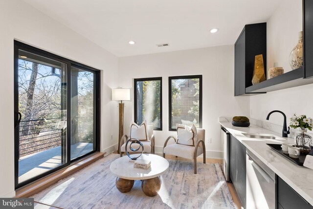 living area with sink and light wood-type flooring