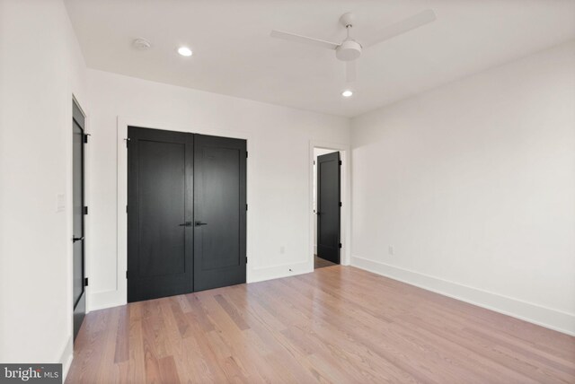 unfurnished bedroom with wood-type flooring, ceiling fan, and a closet