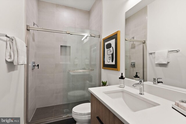 bathroom with vanity, toilet, and an enclosed shower