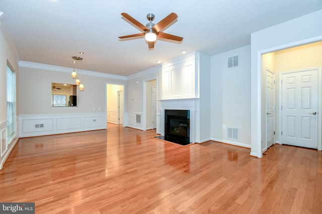 unfurnished living room with crown molding, light hardwood / wood-style floors, and ceiling fan