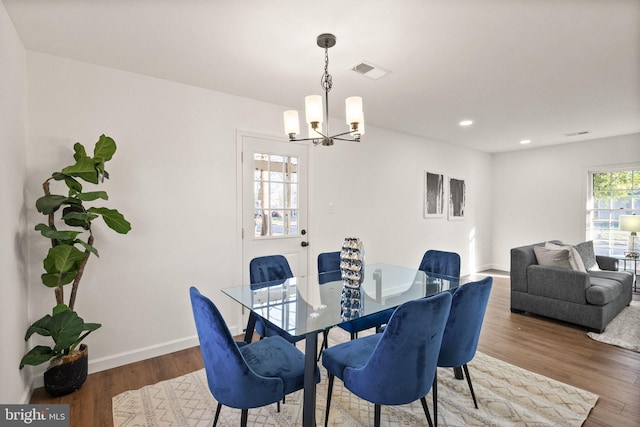 dining space featuring hardwood / wood-style floors and a chandelier