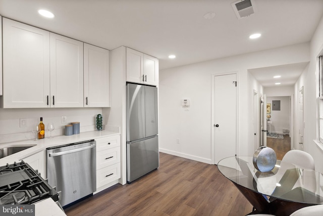 kitchen featuring stainless steel appliances, dark hardwood / wood-style floors, sink, and white cabinets