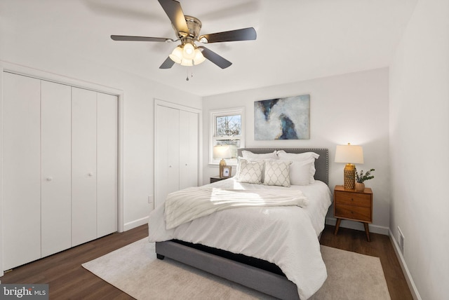 bedroom with multiple closets, ceiling fan, and dark hardwood / wood-style floors