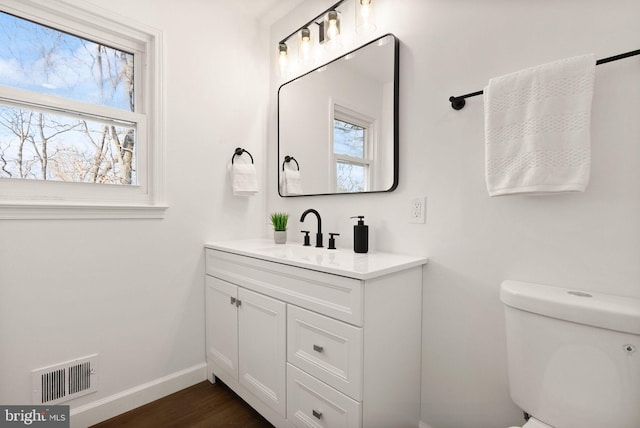 bathroom featuring vanity, wood-type flooring, and toilet