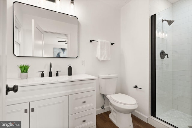 bathroom featuring vanity, hardwood / wood-style floors, toilet, and walk in shower