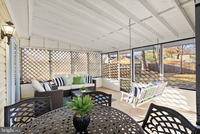 sunroom featuring vaulted ceiling with beams