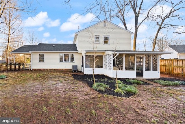 back of property with central AC and a sunroom