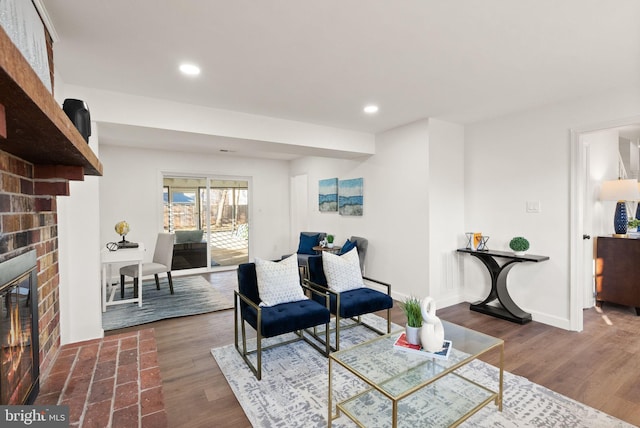 sitting room with dark hardwood / wood-style floors and a brick fireplace