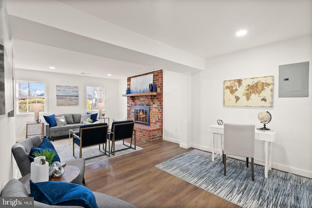 living room with wood-type flooring, electric panel, and a fireplace