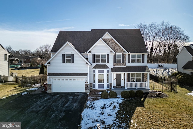 view of front of home featuring a garage, a front yard, and a porch