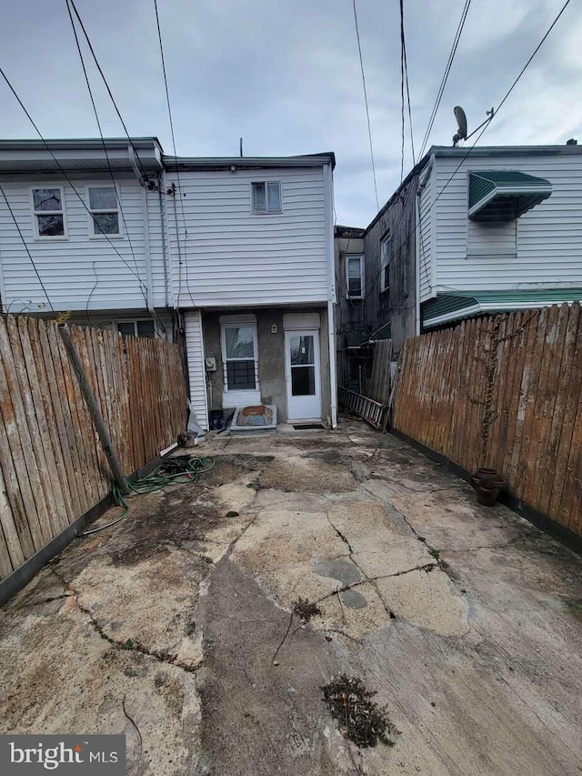 rear view of house featuring fence