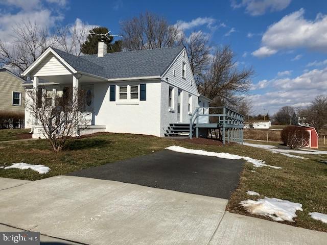 view of side of home featuring a lawn and a porch