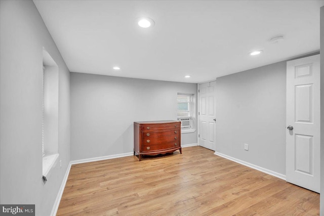 unfurnished bedroom featuring cooling unit and light hardwood / wood-style floors