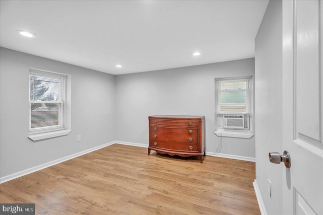 sitting room featuring plenty of natural light, cooling unit, and light wood-type flooring