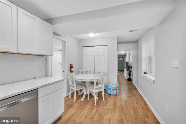 kitchen featuring dishwasher, white cabinets, light stone counters, and decorative backsplash