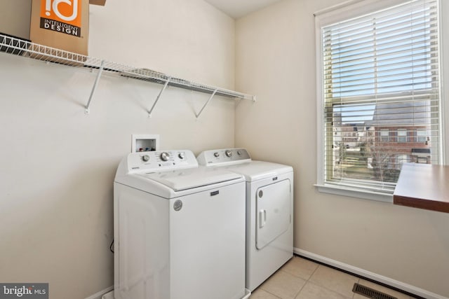 washroom with light tile patterned floors and washer and clothes dryer