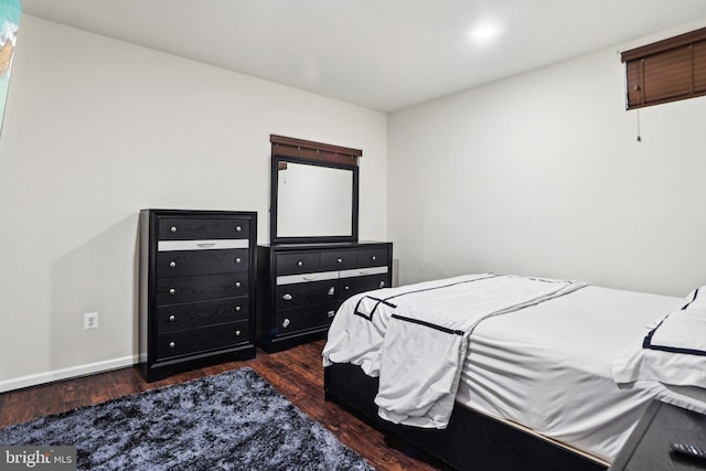 bedroom with dark hardwood / wood-style floors