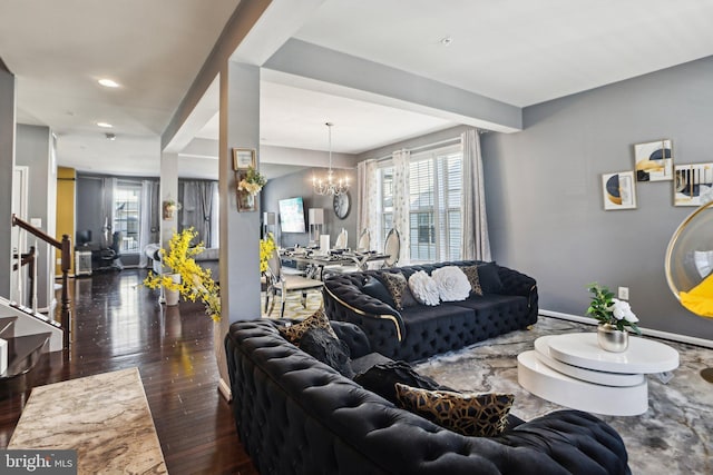 living room featuring dark hardwood / wood-style flooring and an inviting chandelier