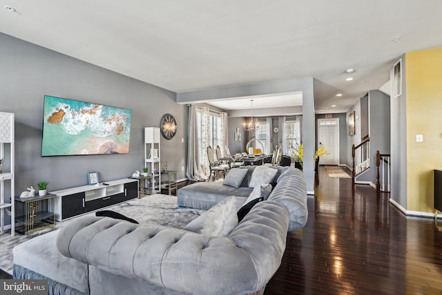 living room featuring an inviting chandelier and dark hardwood / wood-style flooring