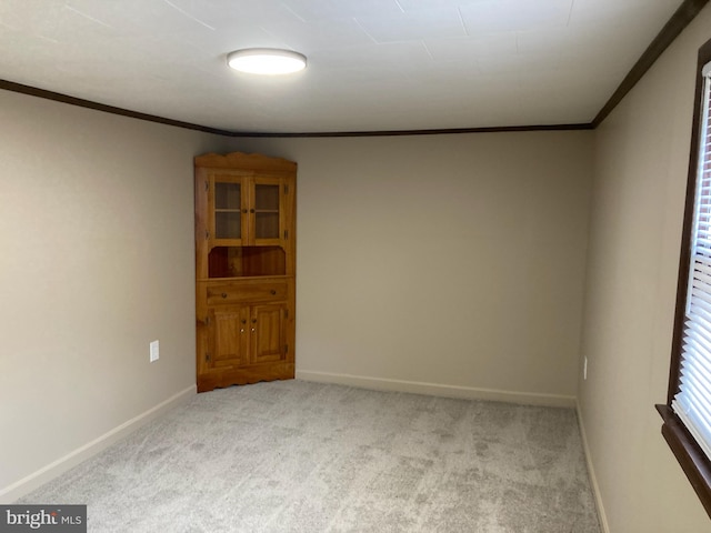 carpeted empty room with crown molding