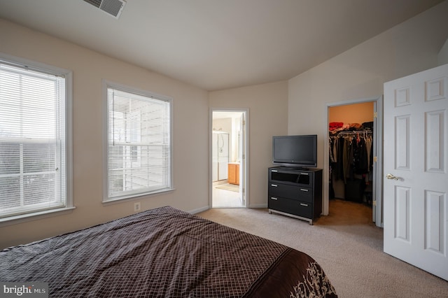 carpeted bedroom featuring a spacious closet, ensuite bath, and a closet