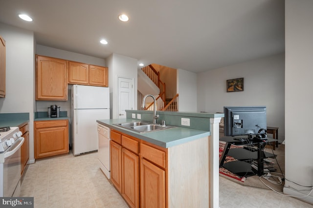 kitchen with white appliances, a kitchen island with sink, and sink