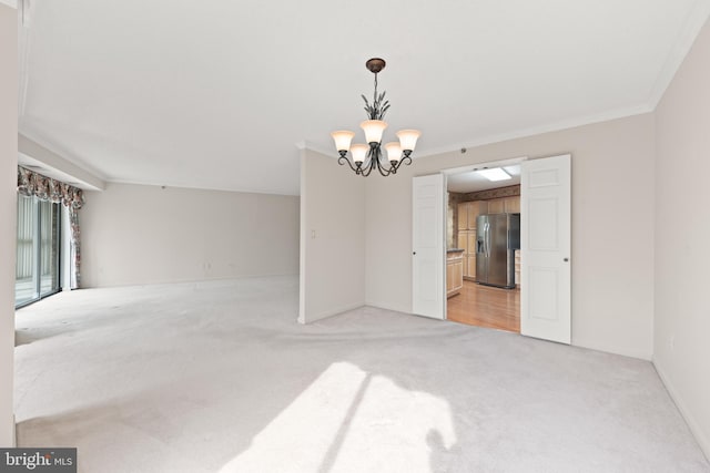 spare room with light colored carpet, ornamental molding, and a notable chandelier