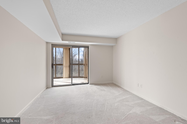 carpeted spare room featuring a textured ceiling