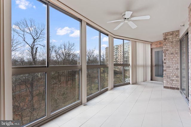 unfurnished sunroom featuring ceiling fan