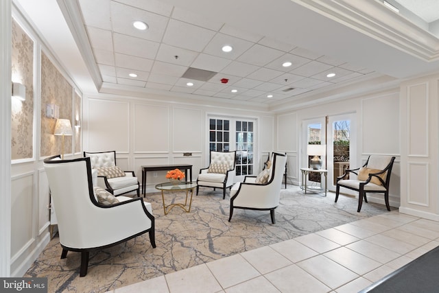 living area with ornamental molding and a raised ceiling