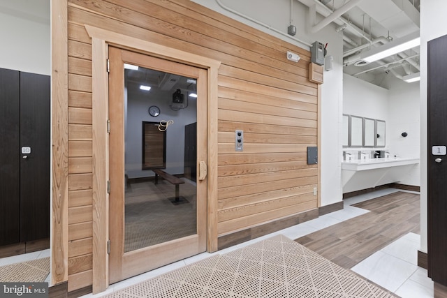 interior space with wood-type flooring and wood walls