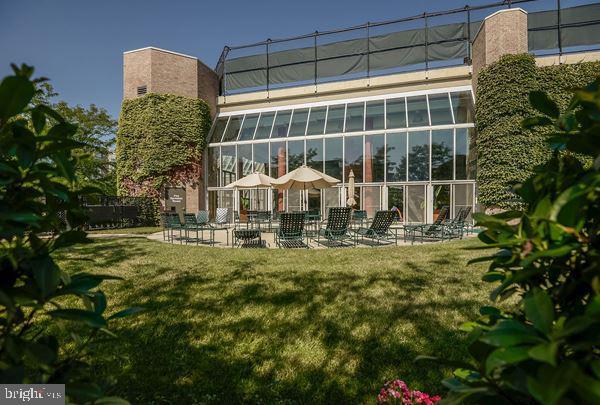 rear view of property featuring a patio area and a lawn