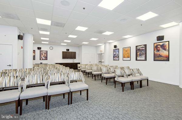 carpeted living room with a drop ceiling