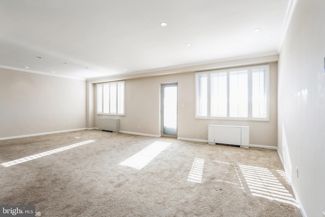 carpeted empty room featuring ornamental molding and radiator heating unit