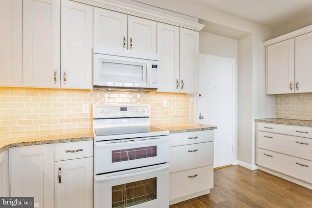 kitchen featuring white cabinetry, light stone counters, light hardwood / wood-style flooring, white appliances, and decorative backsplash