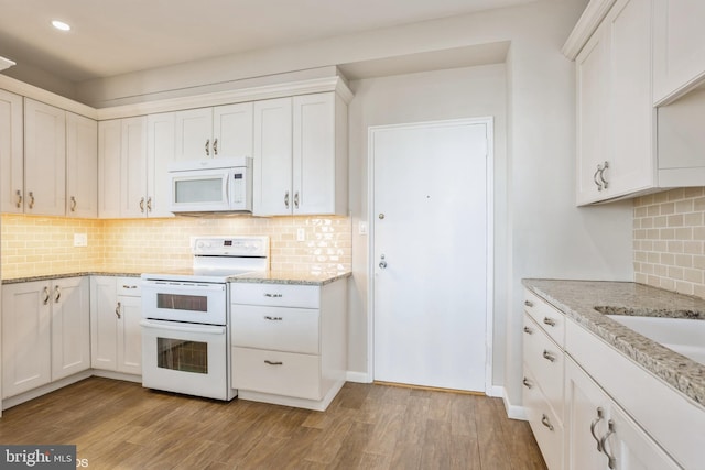 kitchen with white appliances, white cabinets, and light wood-type flooring